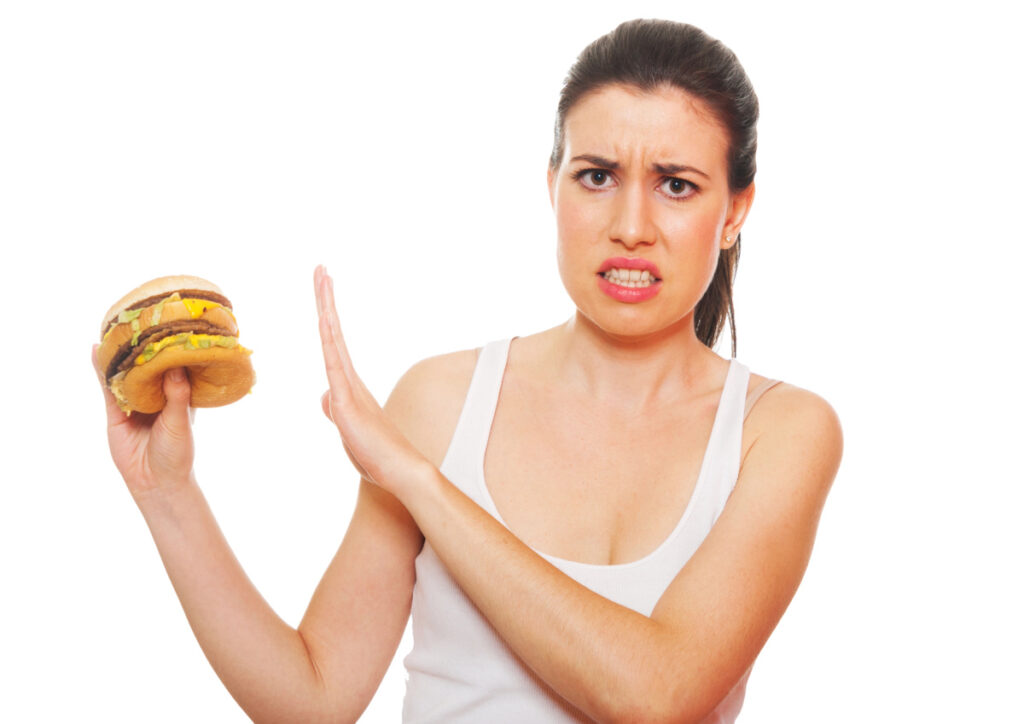 A woman saying no to a food that might trigger acid reflux and cause coughing.