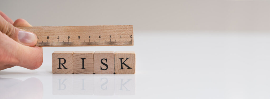 A ruler and the letters spelling out “risk” determining the risks and considerations of a no mesh hernia surgery.